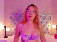 Daphne, a very beautiful and special girl with a sweet face, a mischievous smile, and fiery lips that illuminate every gesture, every sensation in her breasts, in her body. Friendly by nature, smiling and full of life, she touches herself slowly with joy and playfulness, walking seductively, leaving a warm vibe that invites you to stay in her room and learn her secrets. Her gaze says it all: curious, deep, sincere, capable of speaking without uttering a word. Her curly hair frames her essence and seems to invite you to play with the wind and with dreams. She is radiant and uncomplicated, laughing at life and unafraid to show her body, her sensitivity, and her eroticism. She lives for dreams and romance, believes in real connections and simple details. She enjoys the moment, celebrates the everyday, and transforms the small into magic, leaving traces, soft but unforgettable kisses, on those who know her, with joy, passion, tenderness, and constant freedom.